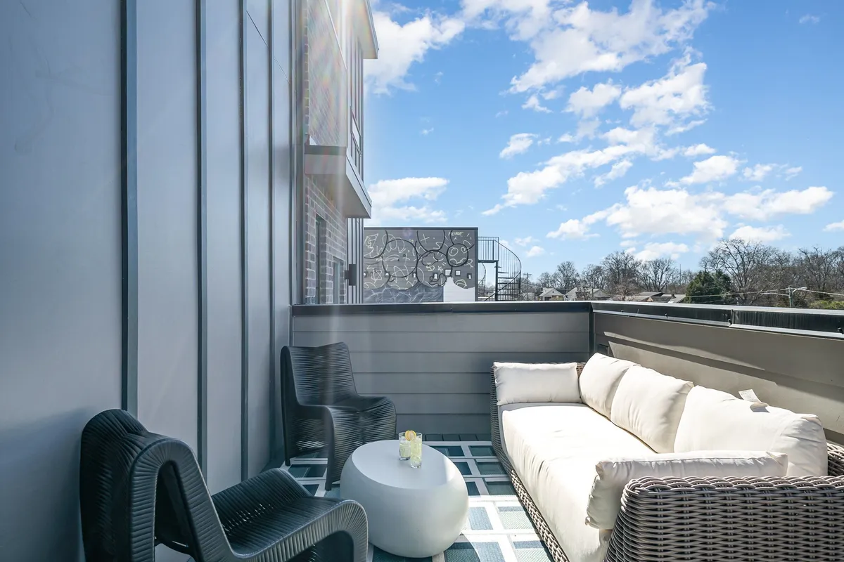 A tranquil rooftop or outdoor seating area with a decorative table and scenic views, inviting guests to relax, socialize, or enjoy the skyline. The sunny ambiance conveys a perfect spot for after-hours networking, informal team gatherings, or evening stargazing sessions.